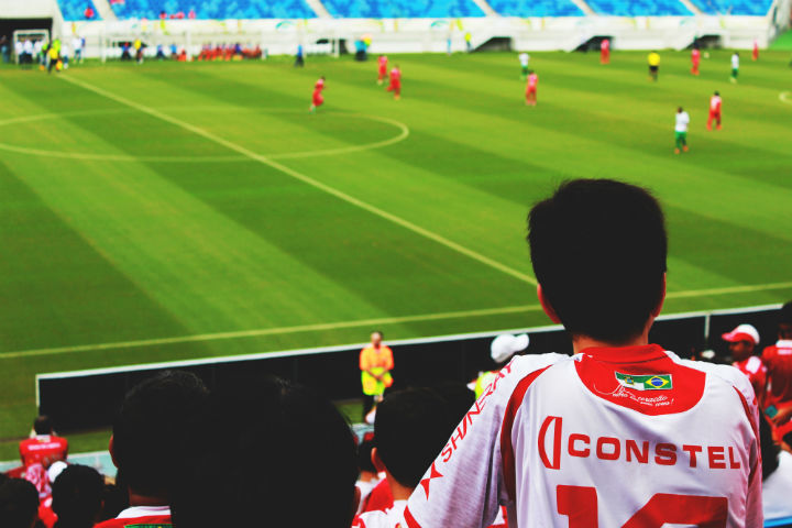 boy watching a soccer game at the stadium