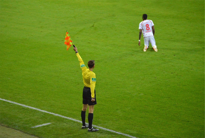 soccer assistant referee holding flag high