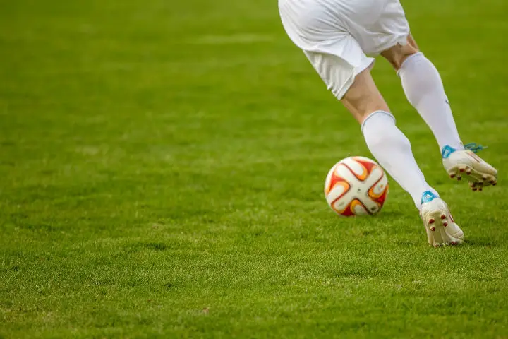 soccer midfielder with ball on field