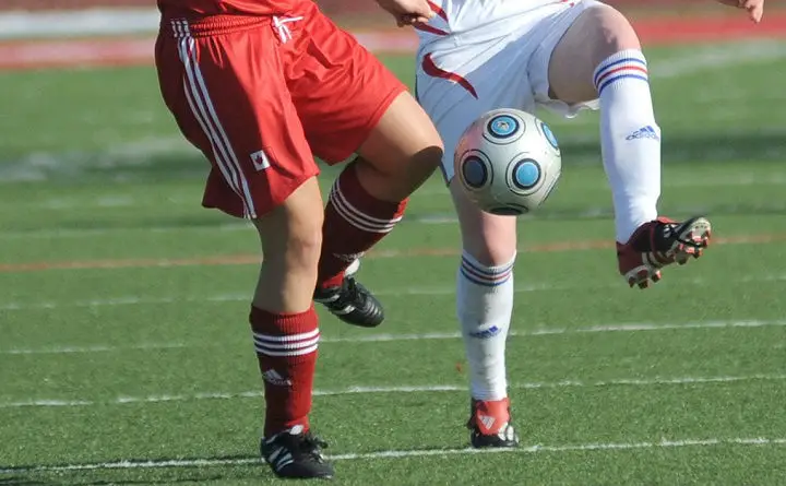 soccer players in red and white during soccer game