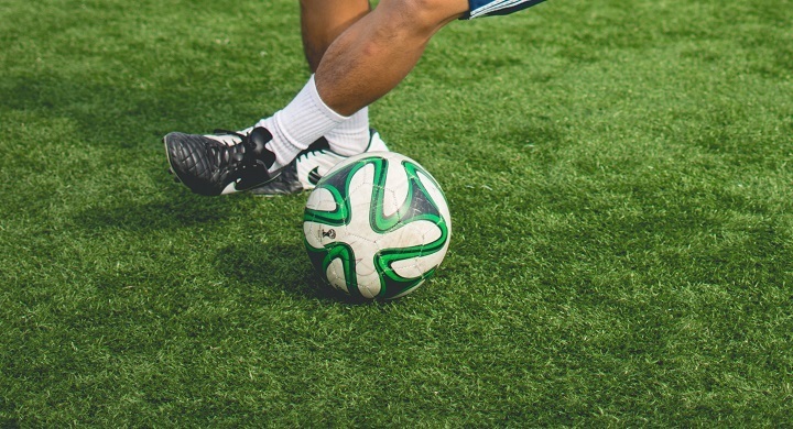 player controlling the soccer ball on the grass field