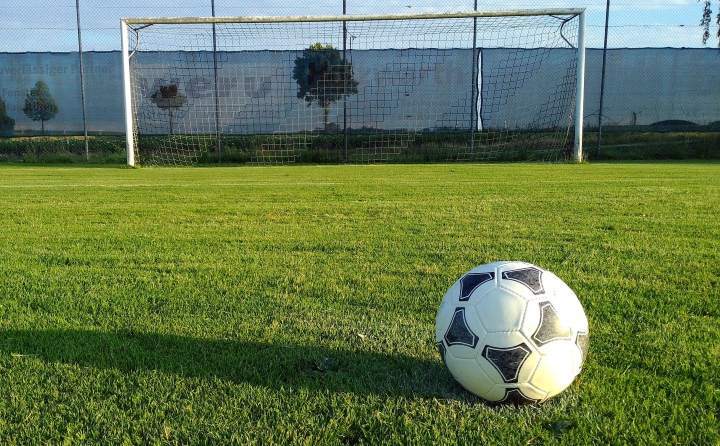 soccer goal and ball on green outdoor pitch