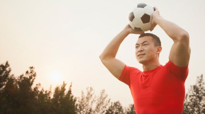 Soccer player in red shirt about to throw in the ball