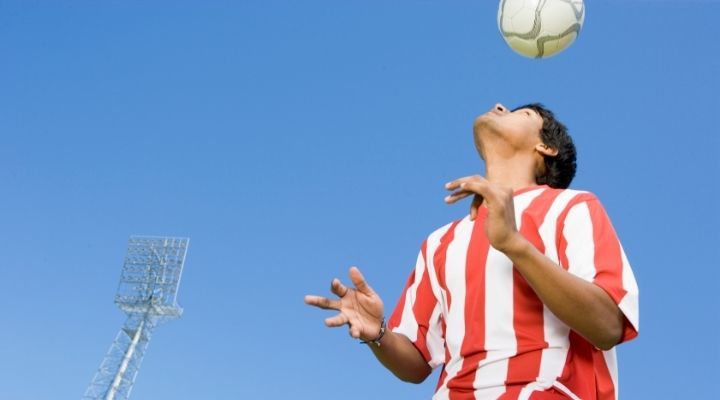 A soccer player hitting the ball with his head