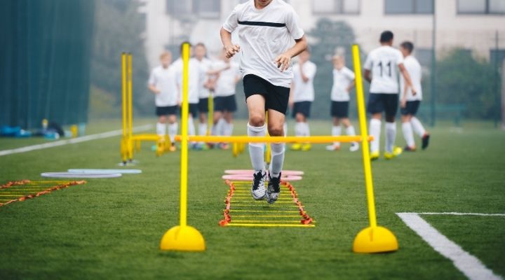 Boys doing agility training on their school's soccer pitch