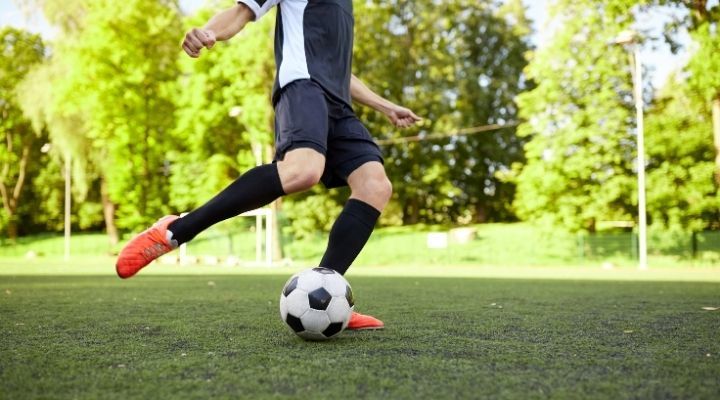 A soccer player practicing his ball control on the field