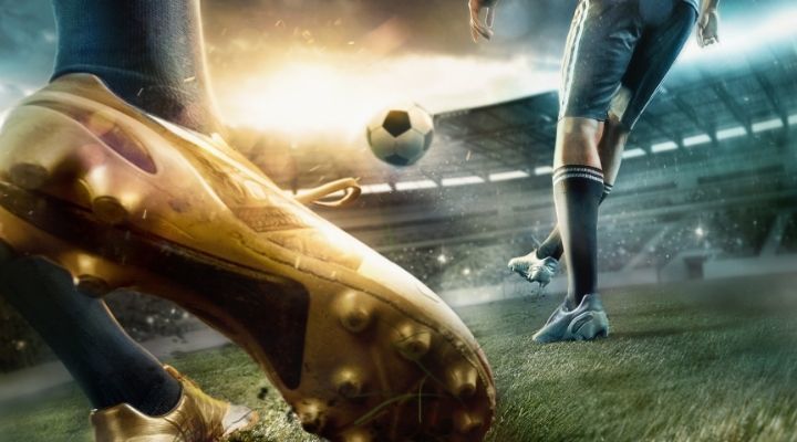 Close-up shot of a golden shoe kicking the soccer ball