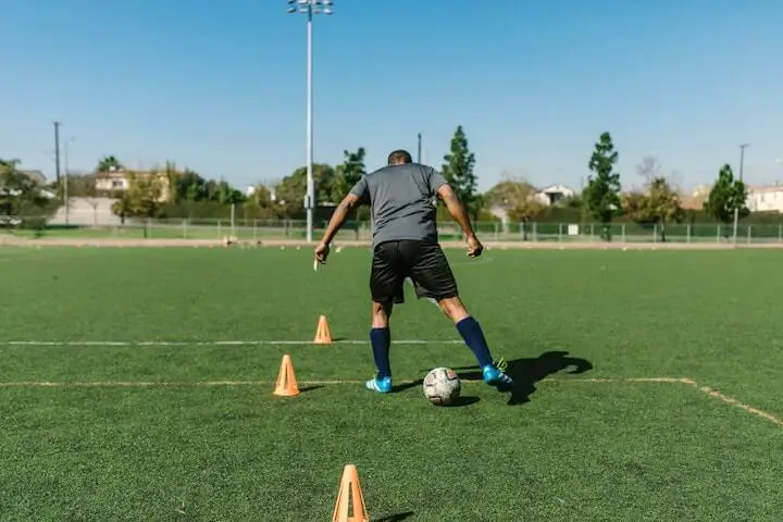 soccer-player-in-blue-cleats-training-with-cones