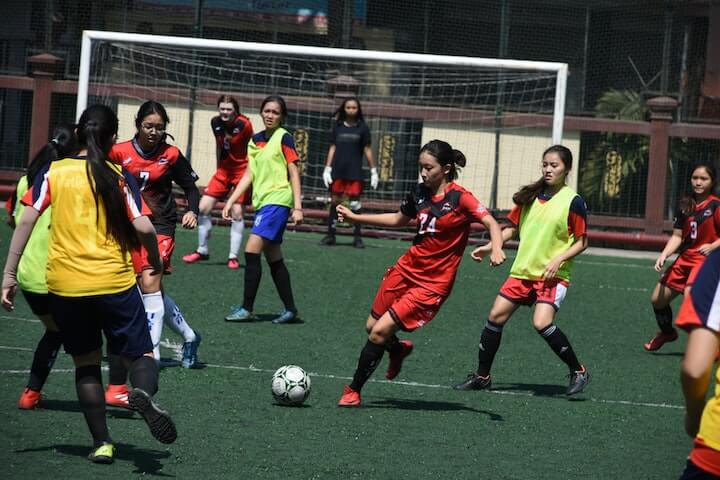 soccer-4-1-2-1-2-formation female-soccer-player-dribbles-the-ball-in-between-defenders