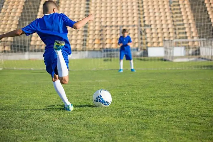 soccer youth player practices striking the ball