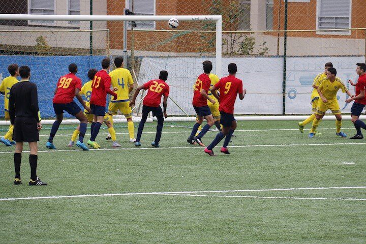 soccer players look on before a goal during a match