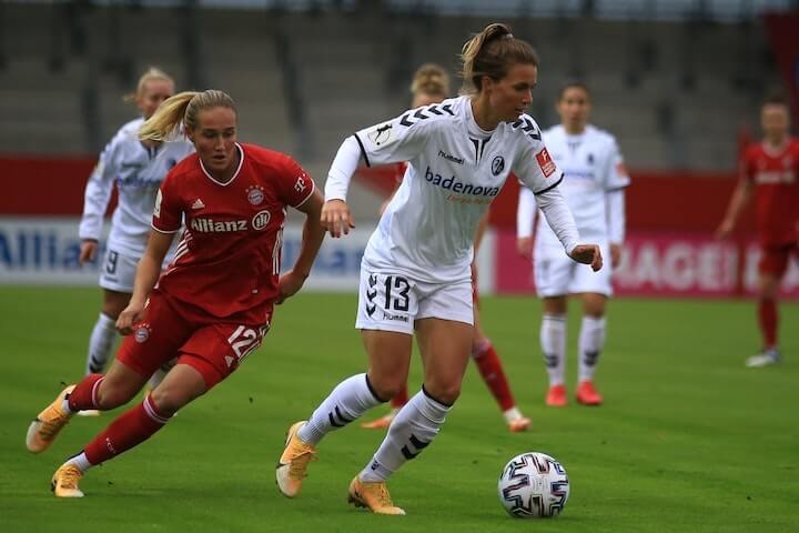 Female soccer player looks to push the ball forward during a soccer match