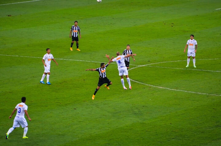 Players fighting for the ball in a 4-1-2-1-2 Formation in Soccer